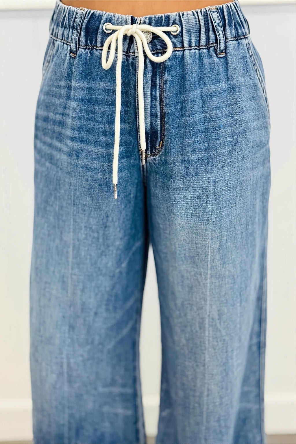 Détail du denim délavé femme, coupe droite confortable pour un look quotidien