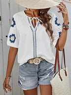 Détail du col V à nouer sur blouse femme brodée contrastée