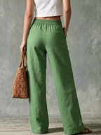 Pantalon vert uni femme coupe fluide taille haute présenté en studio