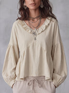 Détail du col V profond et des plis sur la blouse femme