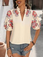 Blouse femme chic fleurie portée avec col montant et volants